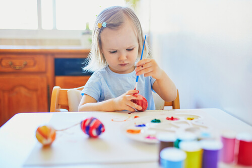 פעוטה משתמשת בציוד יצירה צבעוני