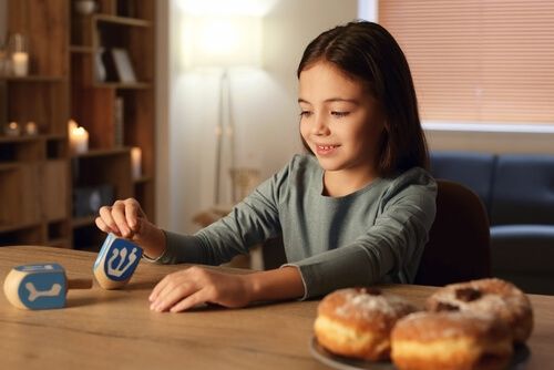 ילדה משחקת עם ערכות יצירה לחנוכה